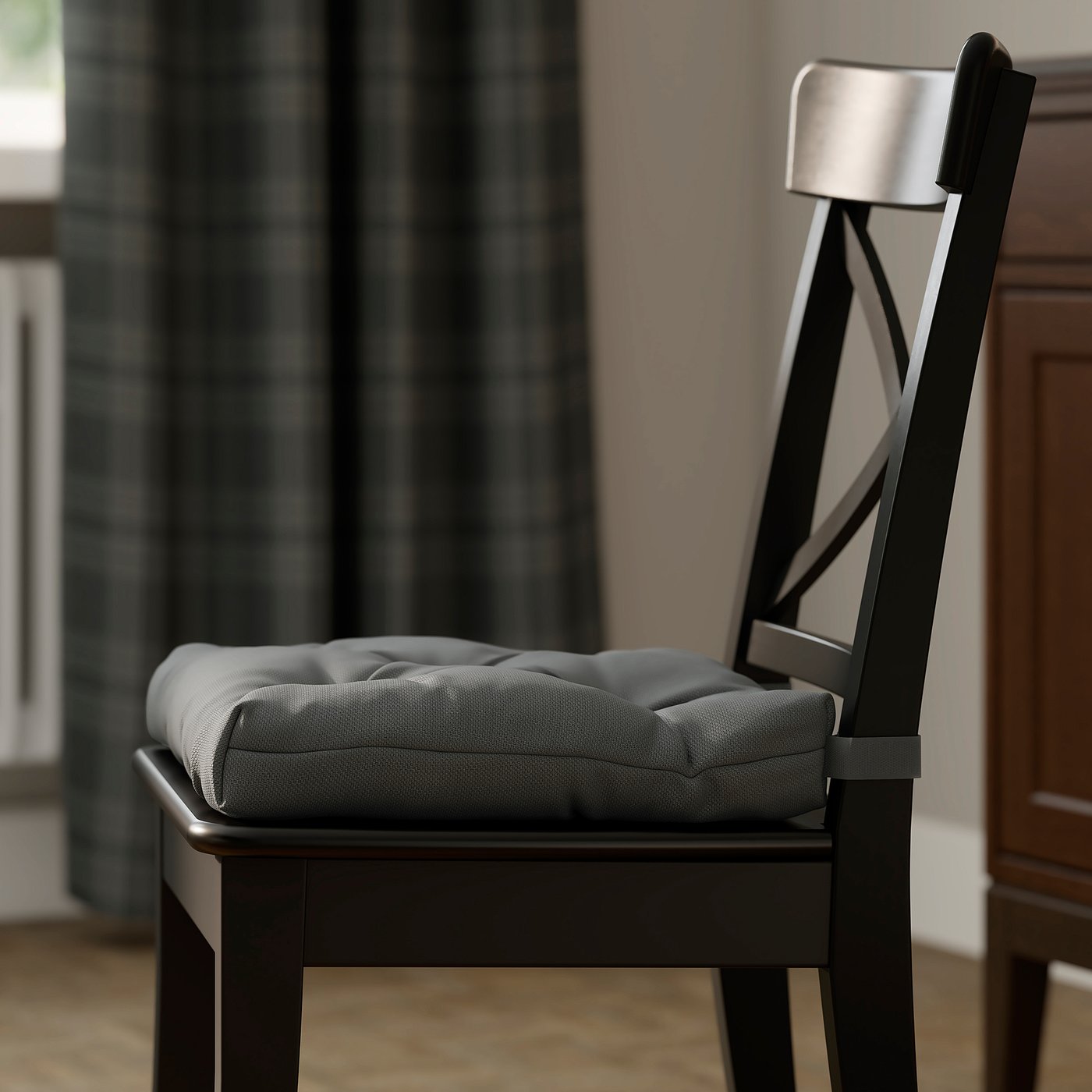 Dark wood chair with grey cushioned seat, black curtains, wooden floor.