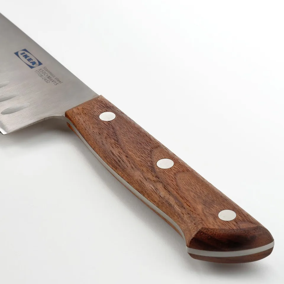 Knife with dark walnut handle, stainless steel blade, three rivets securing handle, and indentations on blade for non-stick cutting.
