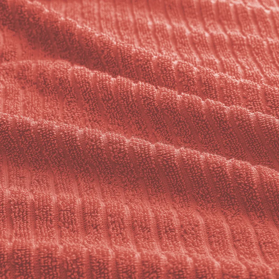 Bright red towel with soft, textured terry loops. Thick and absorbent, a ribbed pattern.