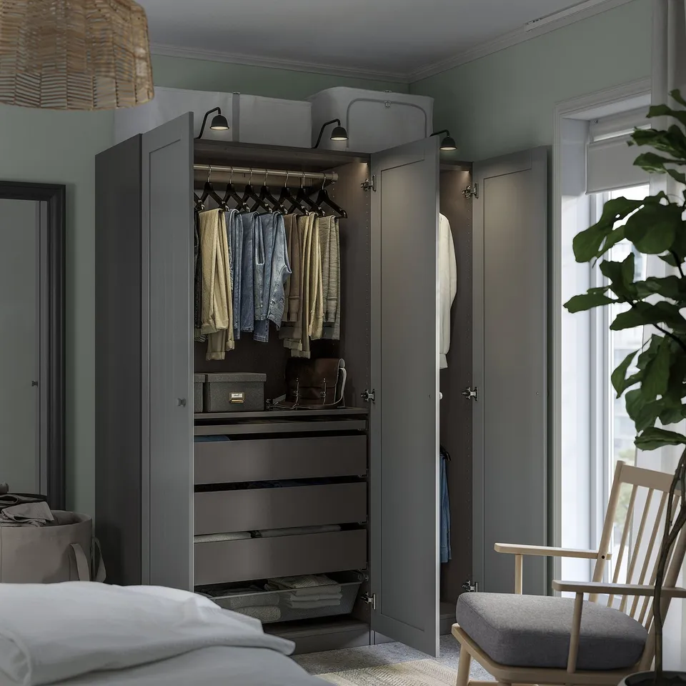A modern grey wardrobe with open doors revealing clothes, drawers, and shelves showcasing its practical and organised interior.