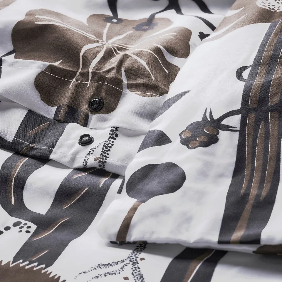 Close-up of duvet cover with floral print and press-stud closure.