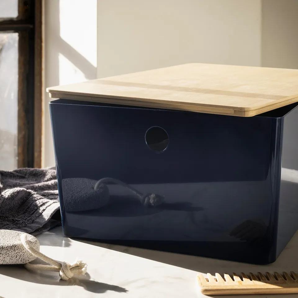 KUGGIS blue box, wooden lid, organise items. Rectangular, glossy. Clear sides, near window. Larger than comb & folded towel.