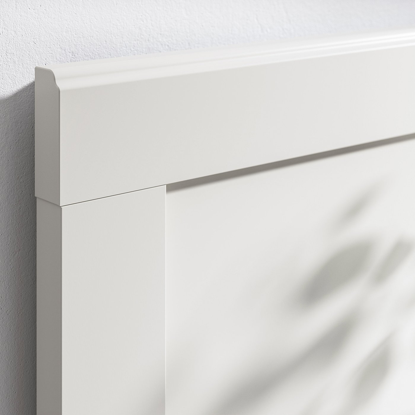 Close-up of a white, high-quality bed frame corner. Shows clean lines and smooth finish.
