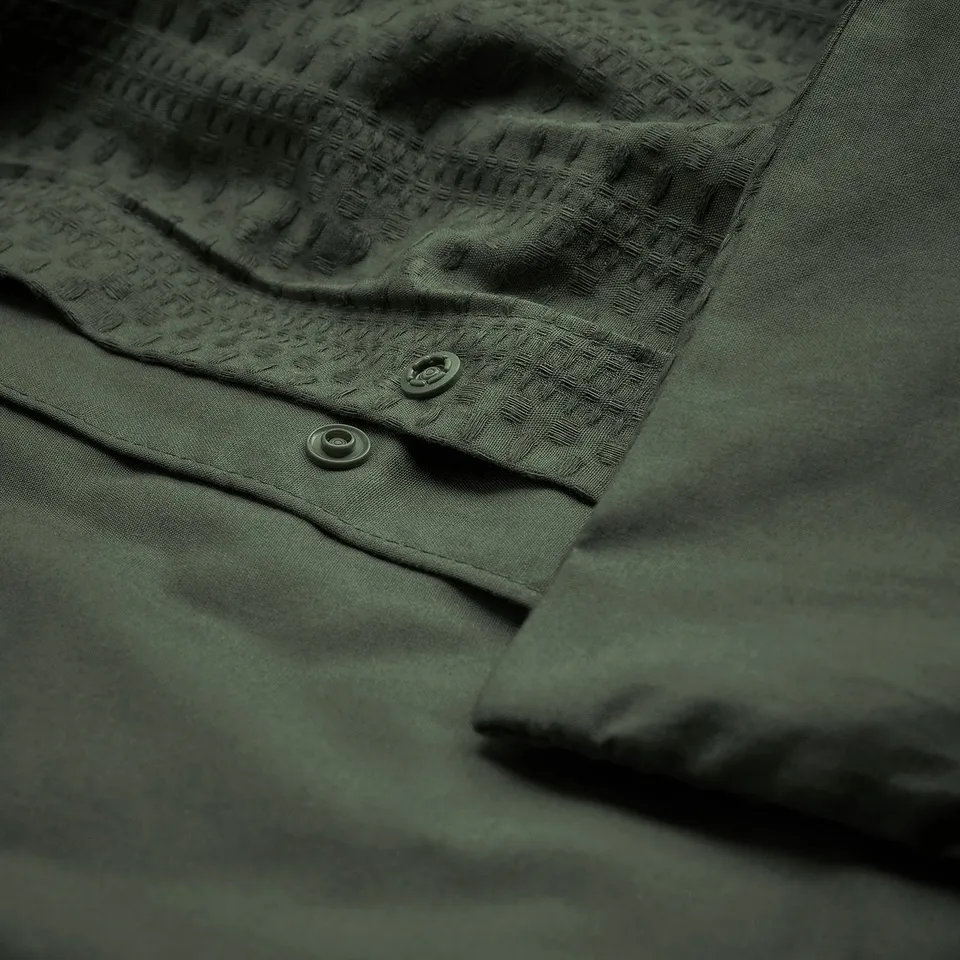 Dark green duvet cover with waffle weave, button closure detail; breathable cotton.