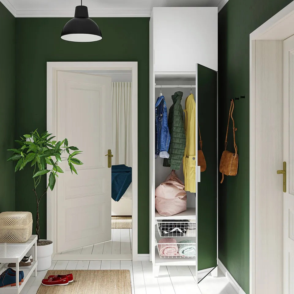 Green entryway with STRAUMEN closet, coats, shelf, bench, plant, lamp, natural light.