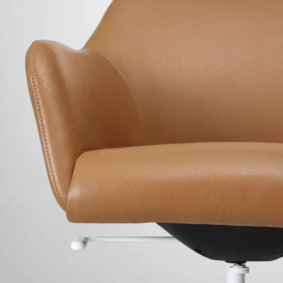 Close-up of a well-crafted, tan leather office chair highlighting its smooth texture and sturdy build.