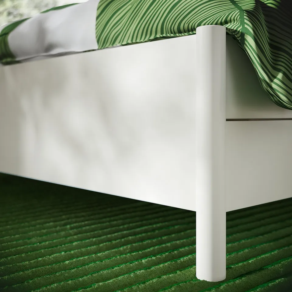 Modern white bed with sleek design, featuring smooth, rounded legs and quality finish, showcasing soft-close drawers and elegant support.