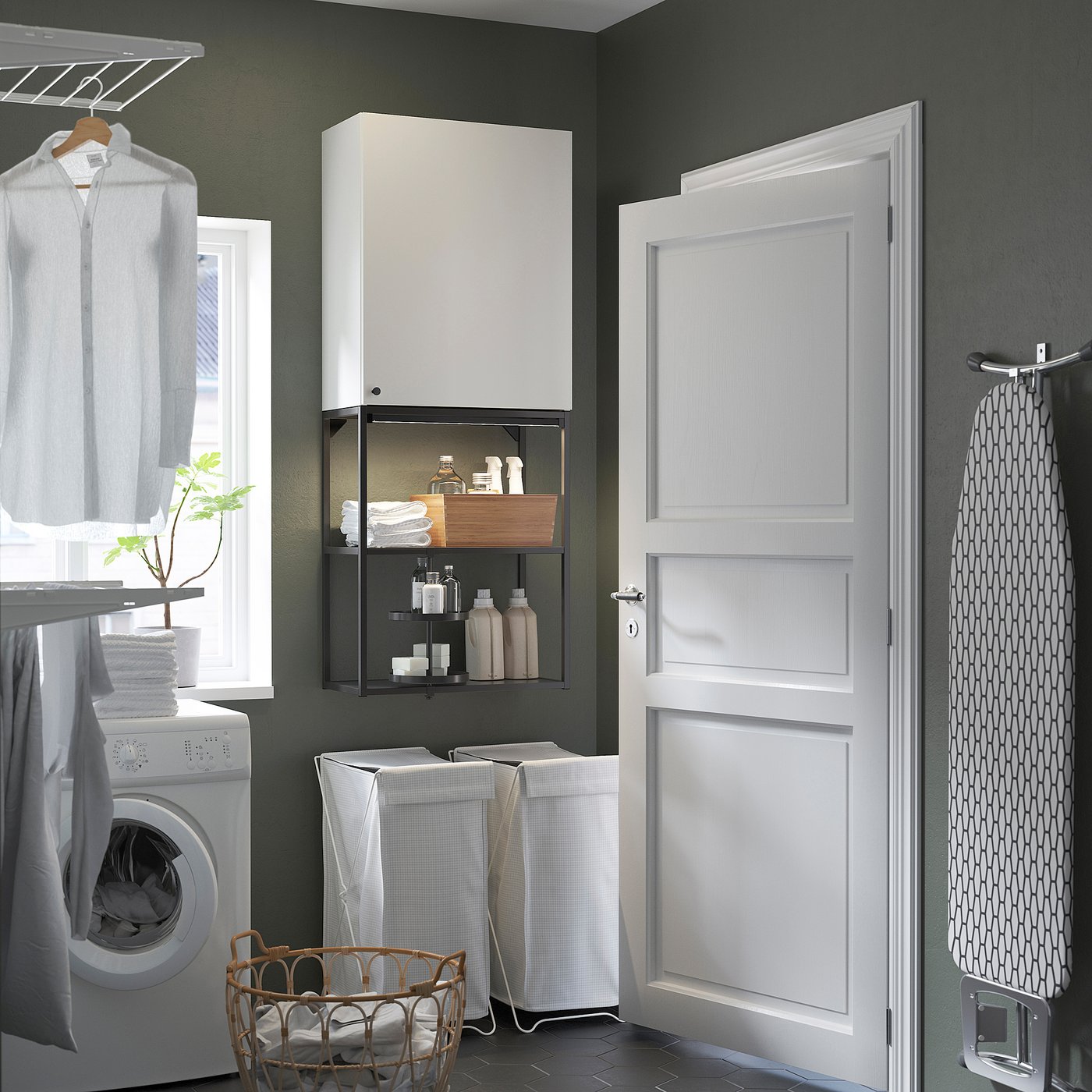 Laundry room with ENHET storage, clothes, washer, and towel basket near door.
