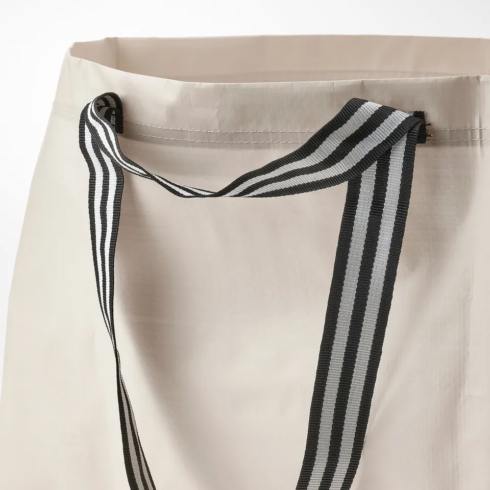 Striped handles on sturdy fabric bag. Durable and stylish design.
