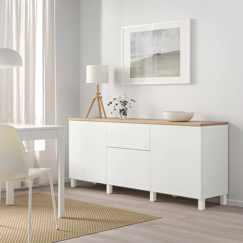 White ikea BESTÅ sideboard with wooden top in dining area.