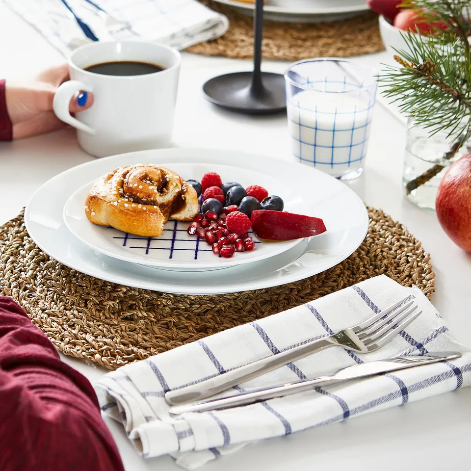 Cedar placemat with pastry, berries, and cutlery.