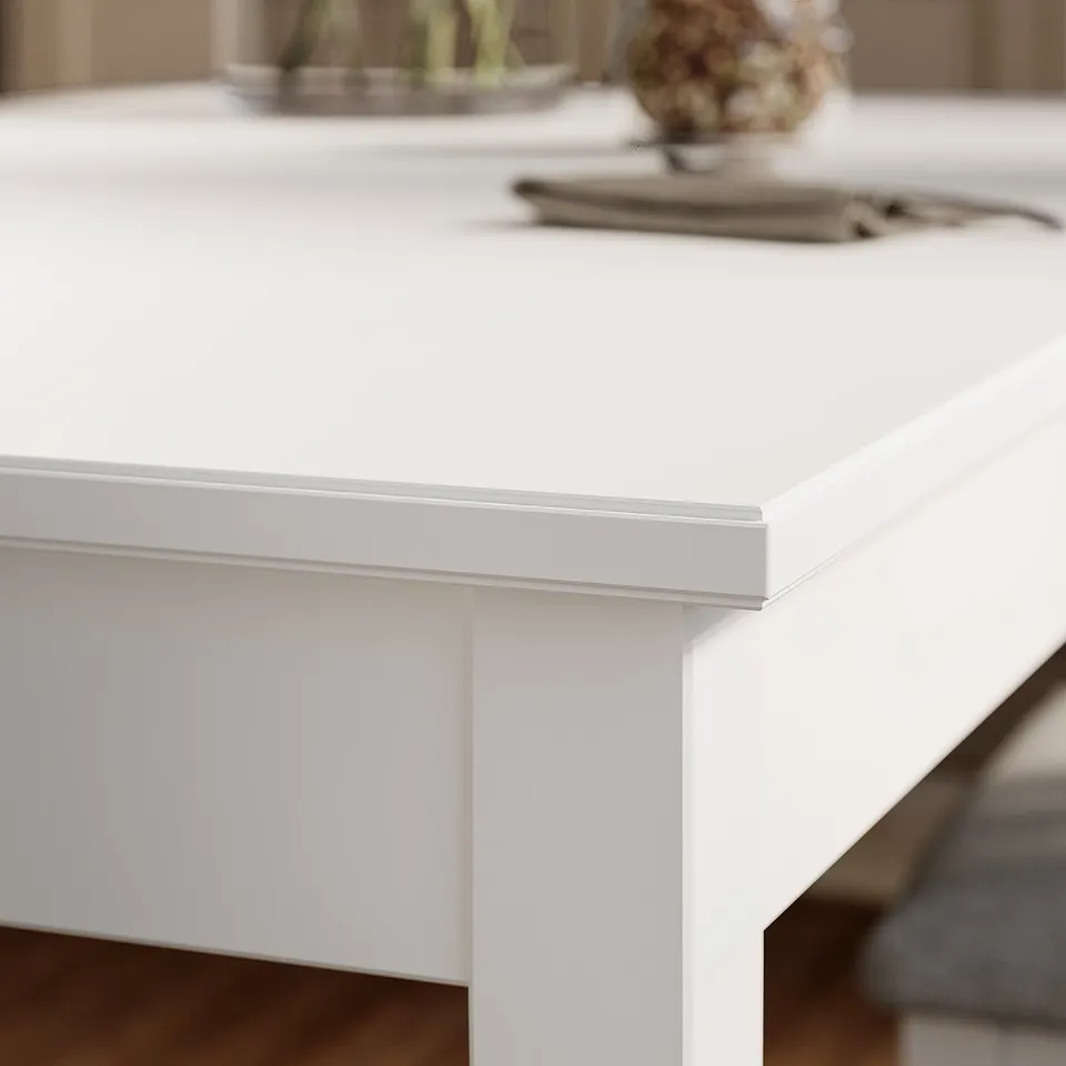 Close-up of a white, sleek table edge with clean lines and smooth finish.
