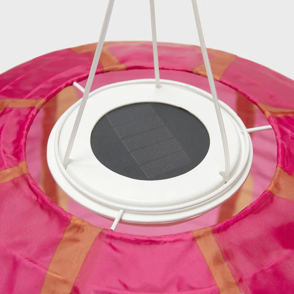 Close-up of a pink SOLVINDEN solar lamp with a white battery box.