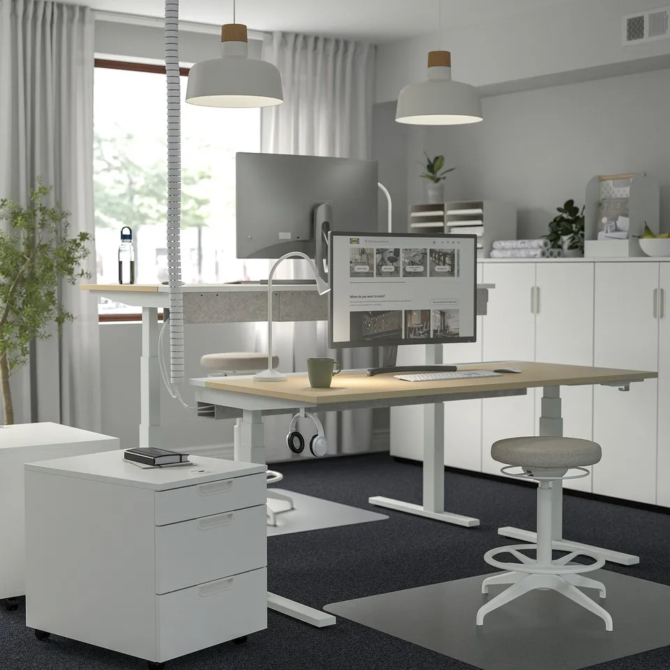 Home office with MITTZON desk, dual monitors, adjustable height, natural light.