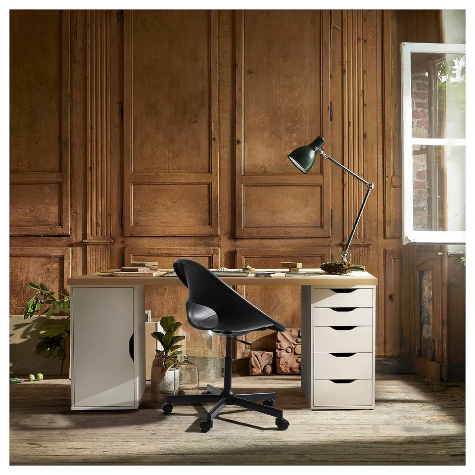 Home office with LAGKAPTEN desk, chair, lamp, drawer, rustic wall, window.