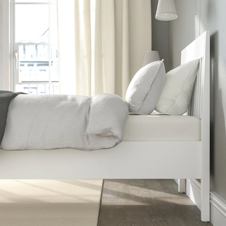 Modern white bed with headboard, clean lines, under-bed storage space.