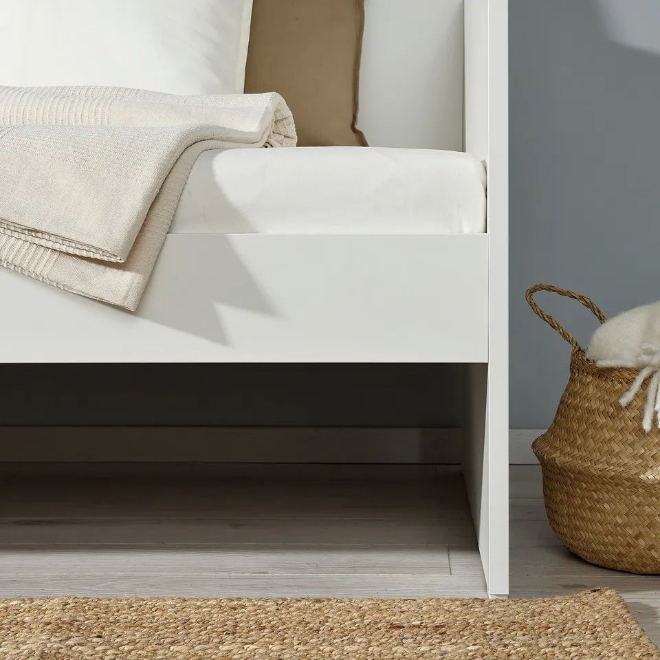 White daybed, rug, basket, multi-use for small spaces.