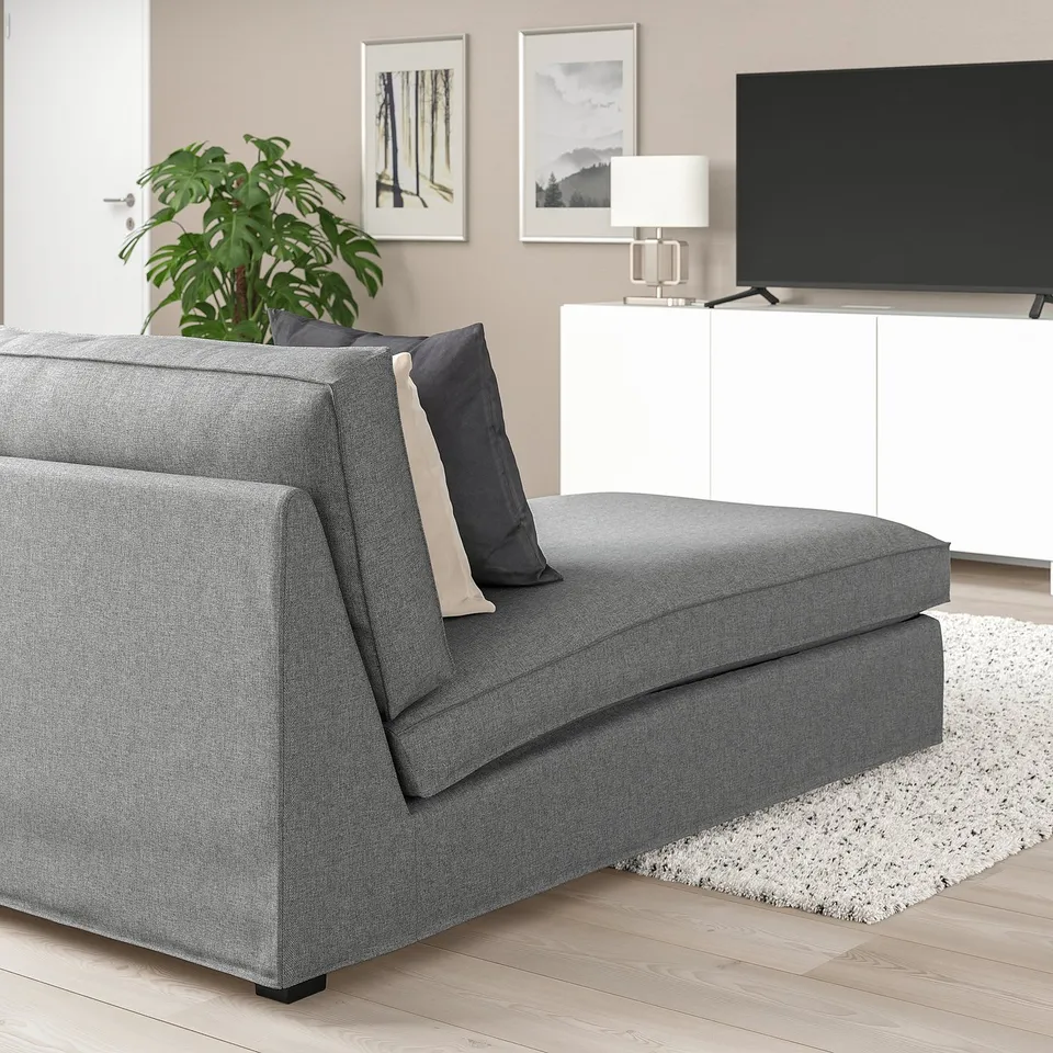 Stylish KIVIK grey chaise in cosy living space, machine-washable fabric, next to console and artwork.