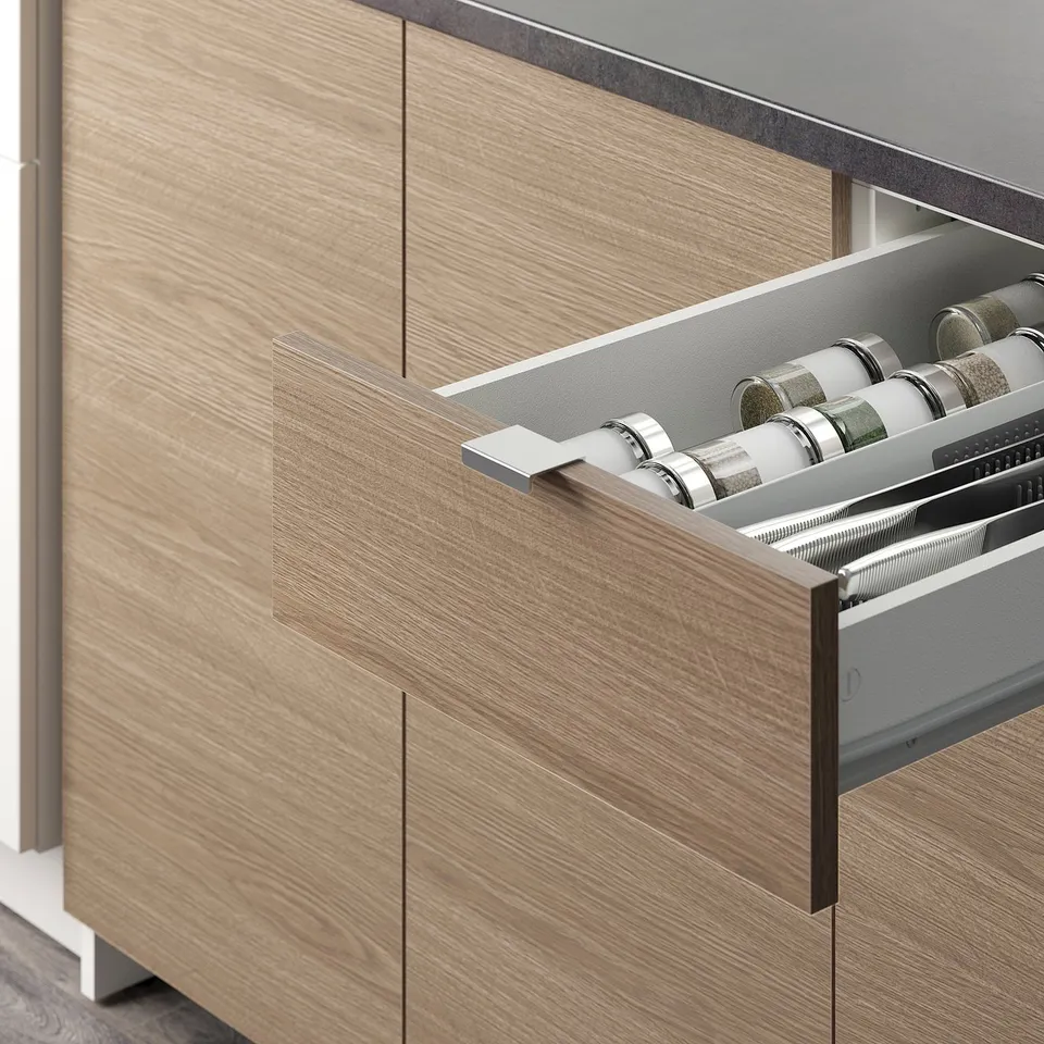 An open kitchen drawer with organised spice jars, part of the KNOXHULT kitchen set known for its storage solutions.