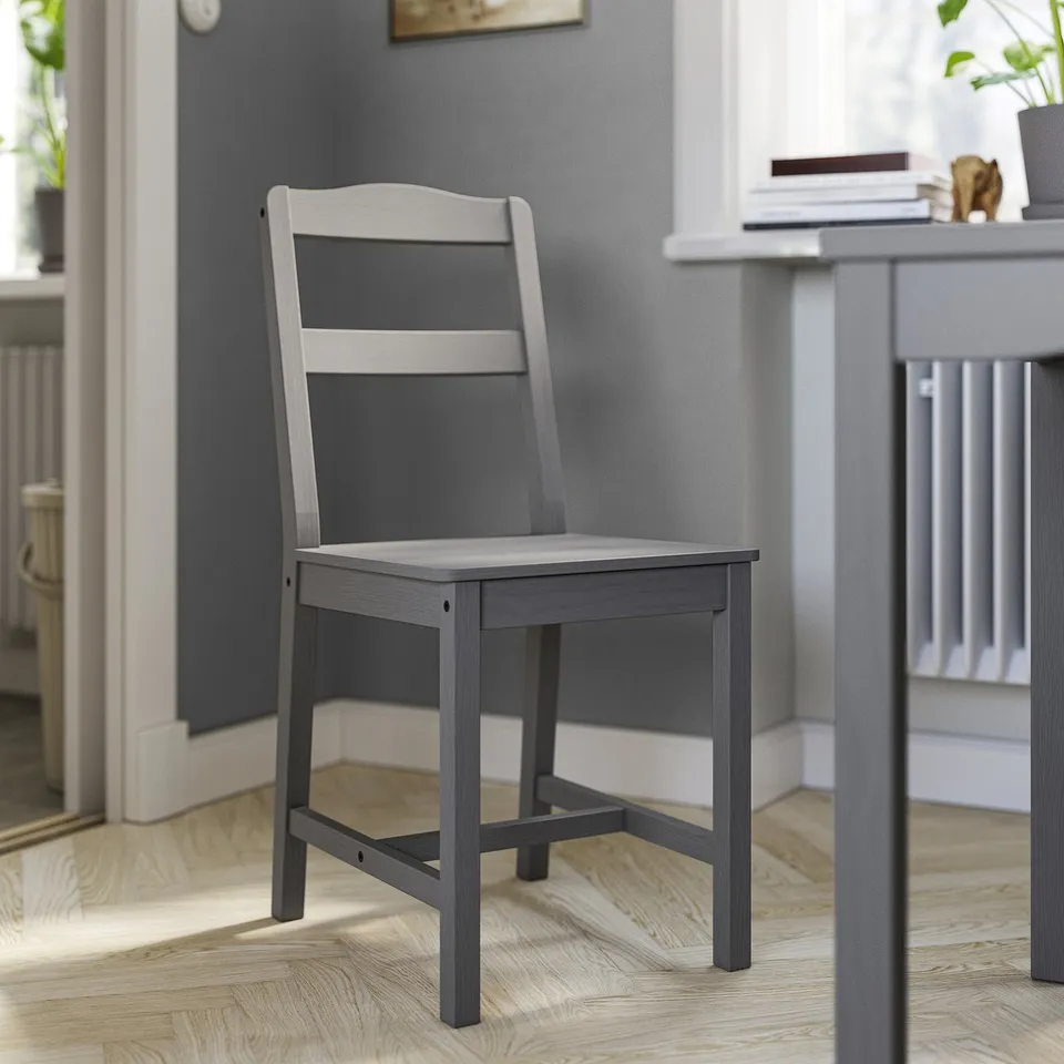 A grey HAUGA wooden dining chair with a high back and vertical slats, set against a dark wall.