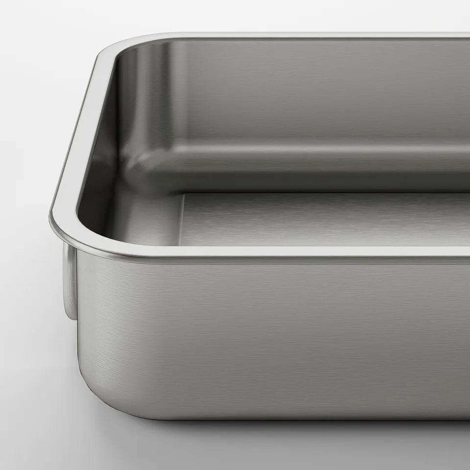Metal roasting tin with handles. Shiny, smooth surface. Rectangular, sturdy design.
