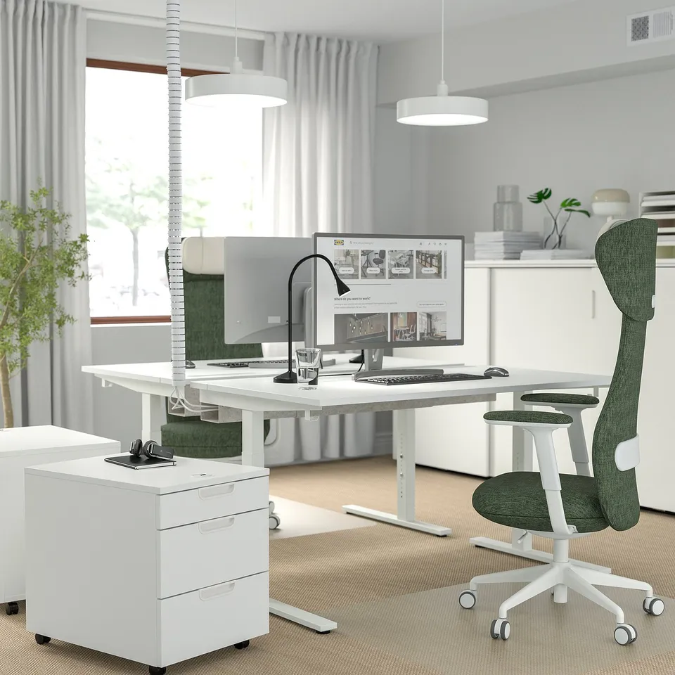 MITTZON height-adjustable desk, computer setup, green chair, well-lit room.