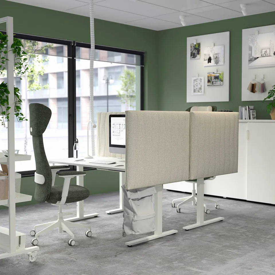 Modern workspace with MITTZON standing desk and chair. Green walls, big windows, shelves with books, comfortable and ergonomic.
