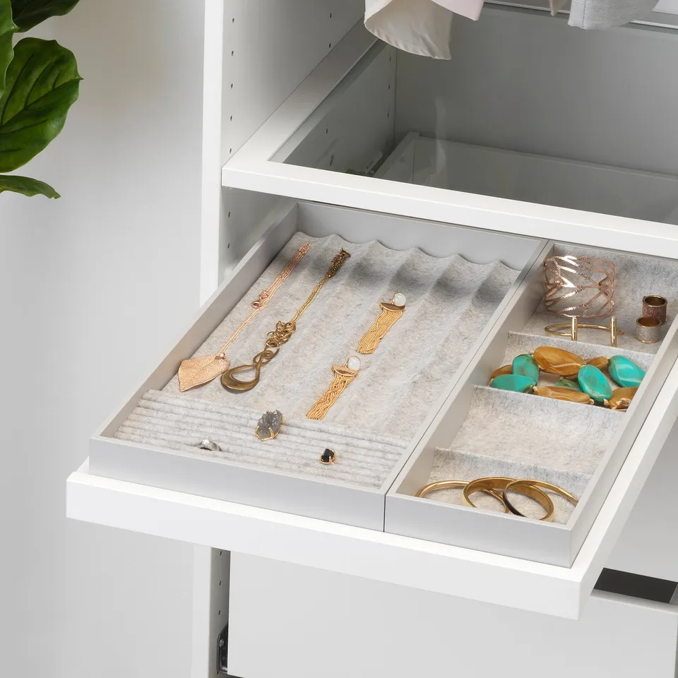 White drawer organiser with compartments for necklaces, rings, earrings, and bracelets.