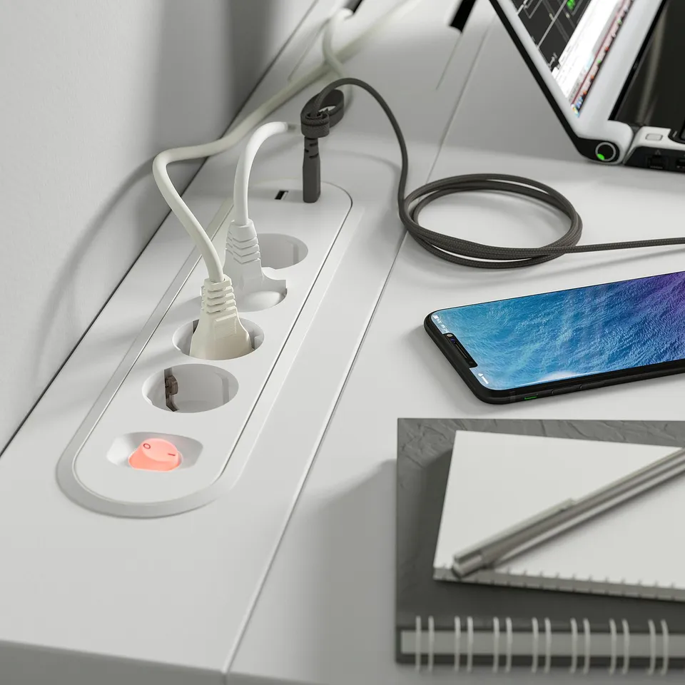 Desk with built-in outlet and cable tray. Plugs in, holds smartphone, pen, and notebook.