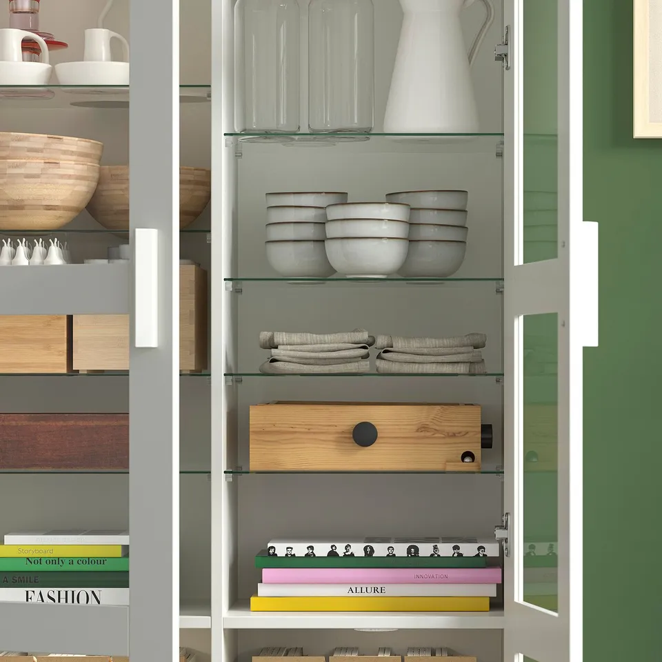Shelves with clear drawers, stacked bowls, books, and folded textiles, demonstrating organised storage.