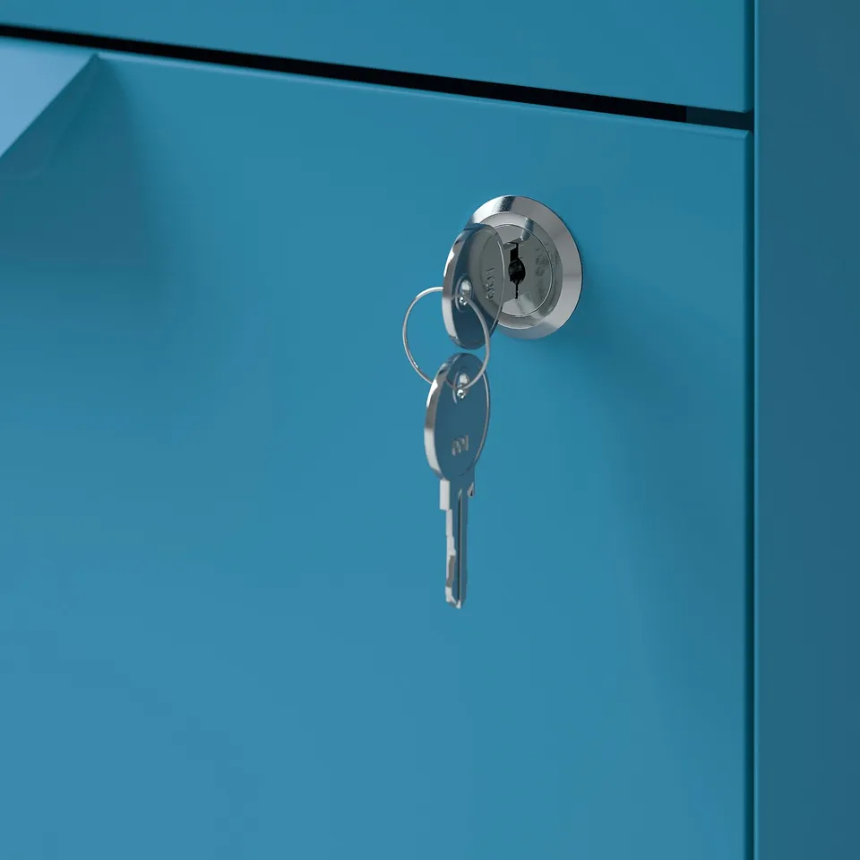 A close-up of a blue metal cabinet with a round keyhole lock and silver keys inserted.