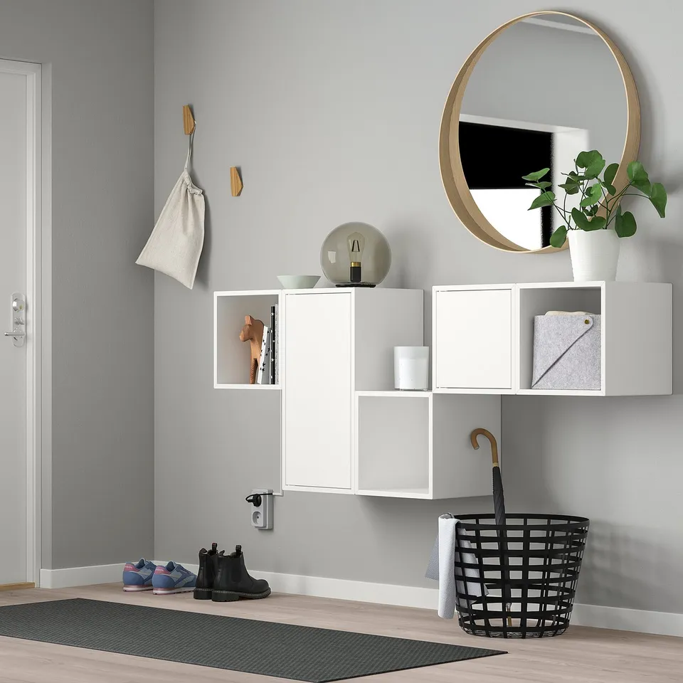 Modern entryway with white EKET storage, mirror, and rug.