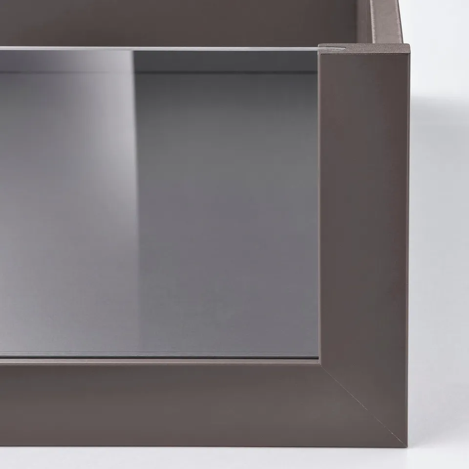 Dark furniture close-up showing sleek metal edge and mirrored surface, highlighting quality and modern design.