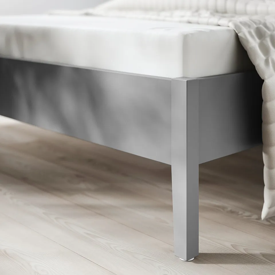 Close-up of a sturdy, modern bed frame featuring sleek metal legs and a slatted bed base, designed for both style and durability.