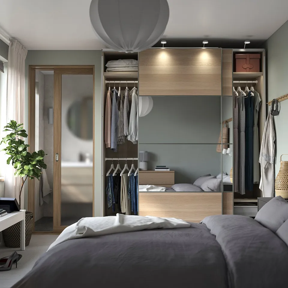 Modern bedroom with grey bed, wooden closet, pendant light.