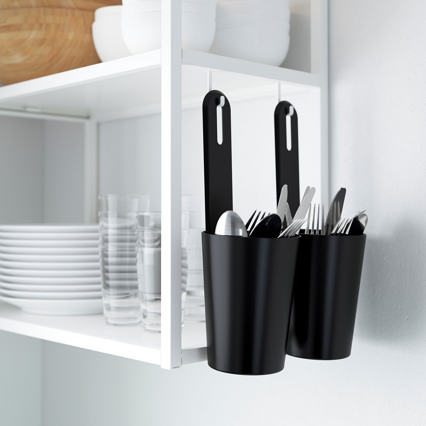 Black storage containers hold utensils on wall, part of ENHET kitchen organisation series.
