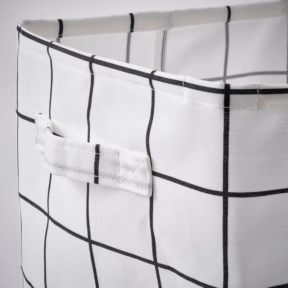 White mesh storage bin with black trim and handles, attached to a shelf.