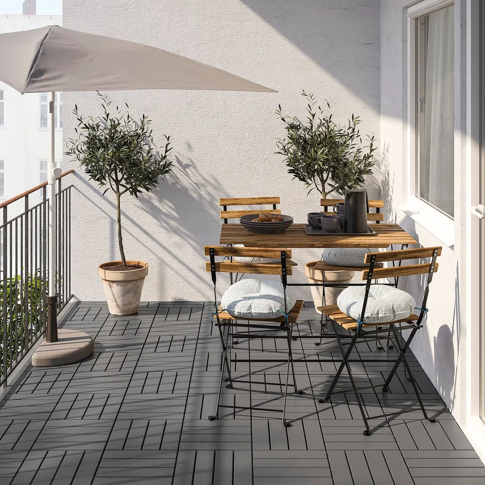 Small outdoor dining set with acacia wood table and black metal chairs. Perfect for balconies, foldable design.