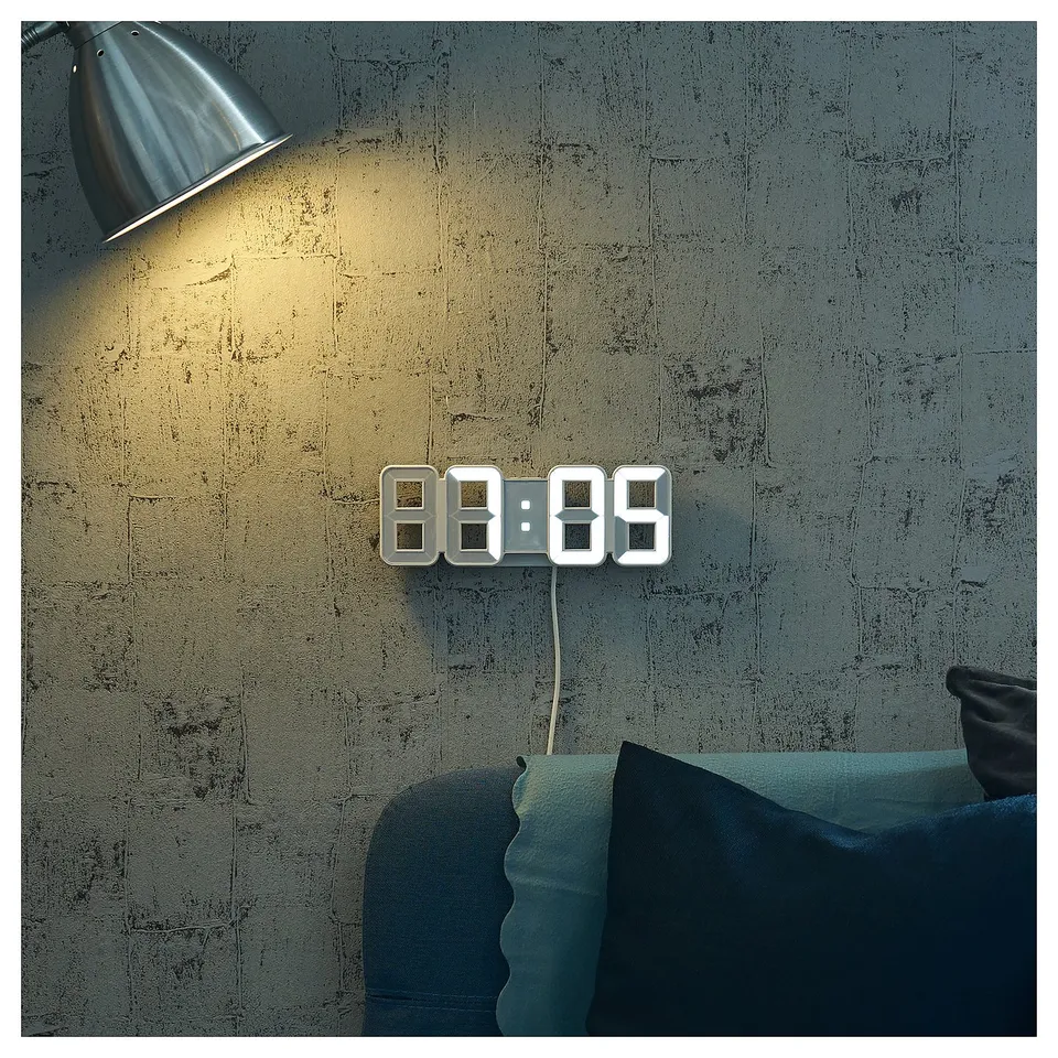 NOLLÅTTA clock on grey wall, time 8:89, with pillow.