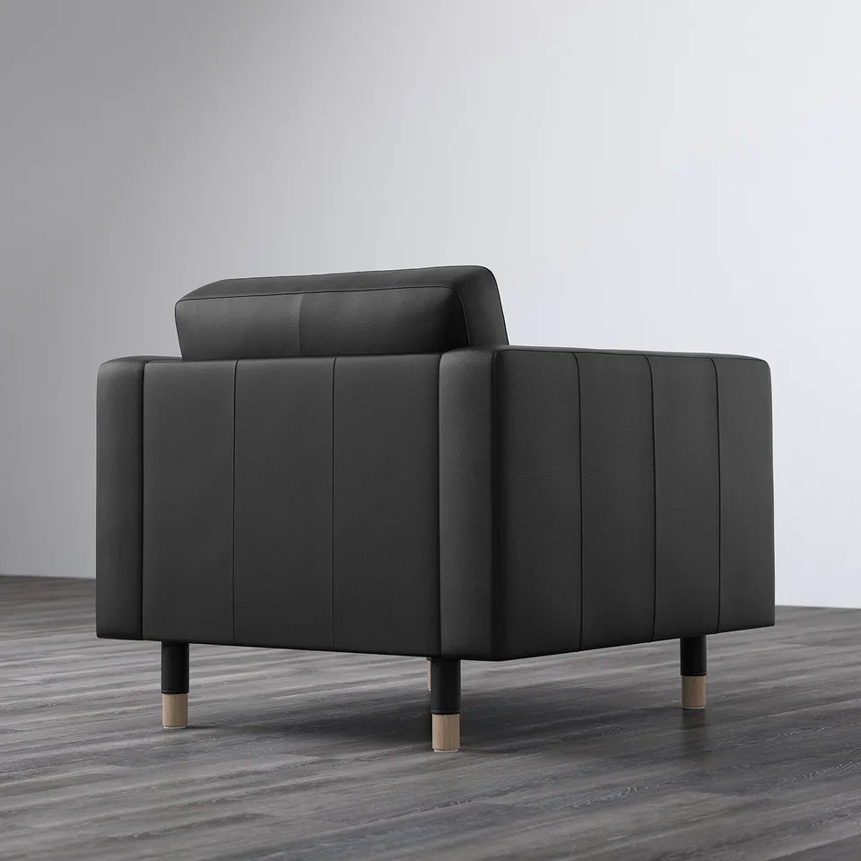 Modern black armchair with cushioned seat and back, sturdy wooden legs, cosy and stylish for comfort.