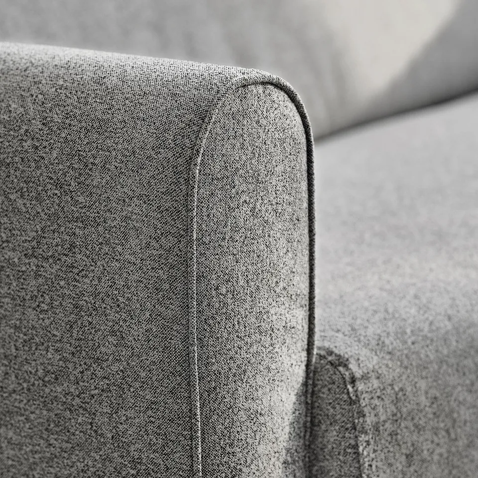 Close-up of modern sofas sleek, upholstered arm. Cushion details visible.