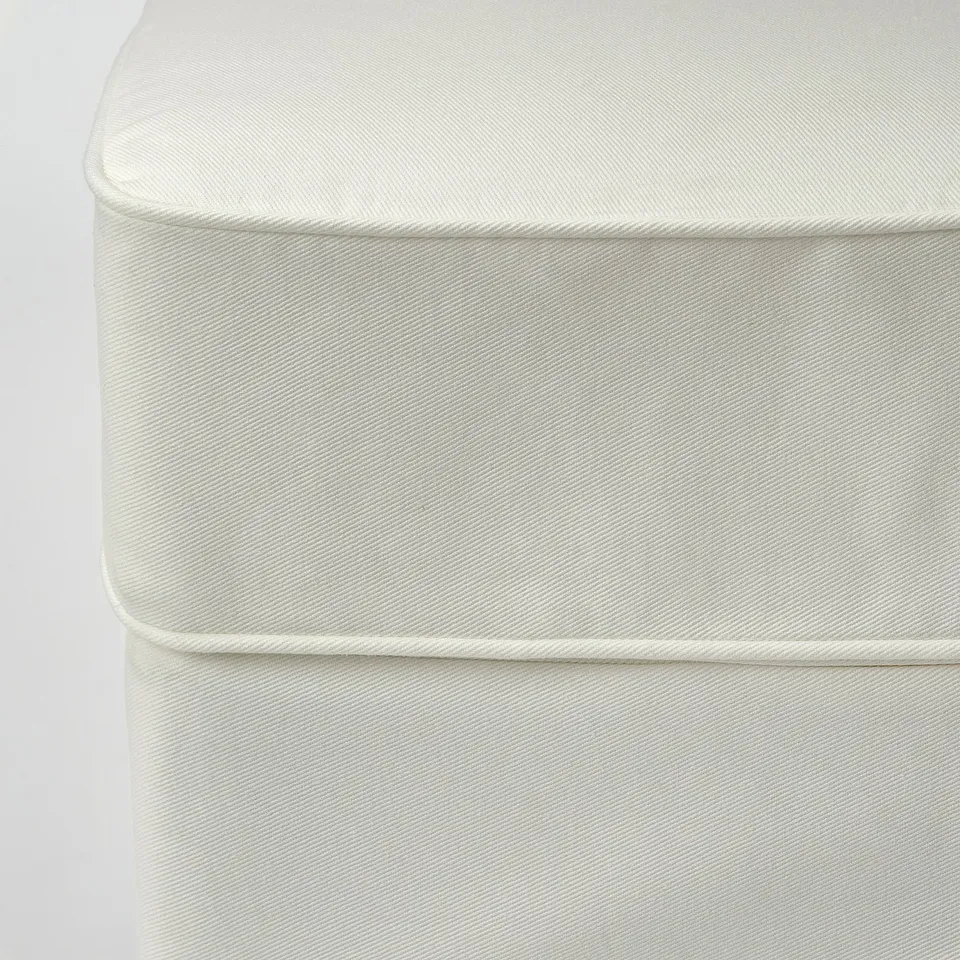 Close-up of white, textured, high-quality sofa fabric with neat stitching.