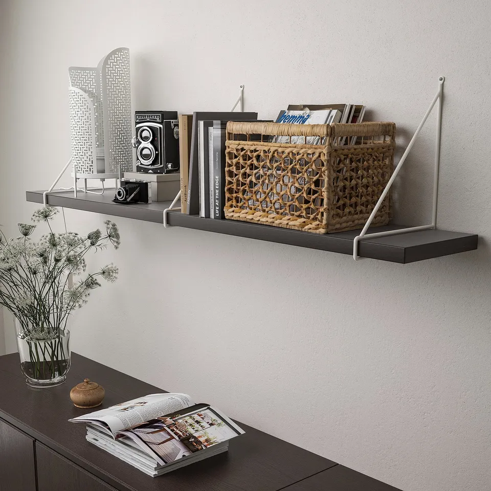 Wall-mounted shelves with books, magazines, and decorative items. The shelves have a bevelled edge and are supported by metal brackets.