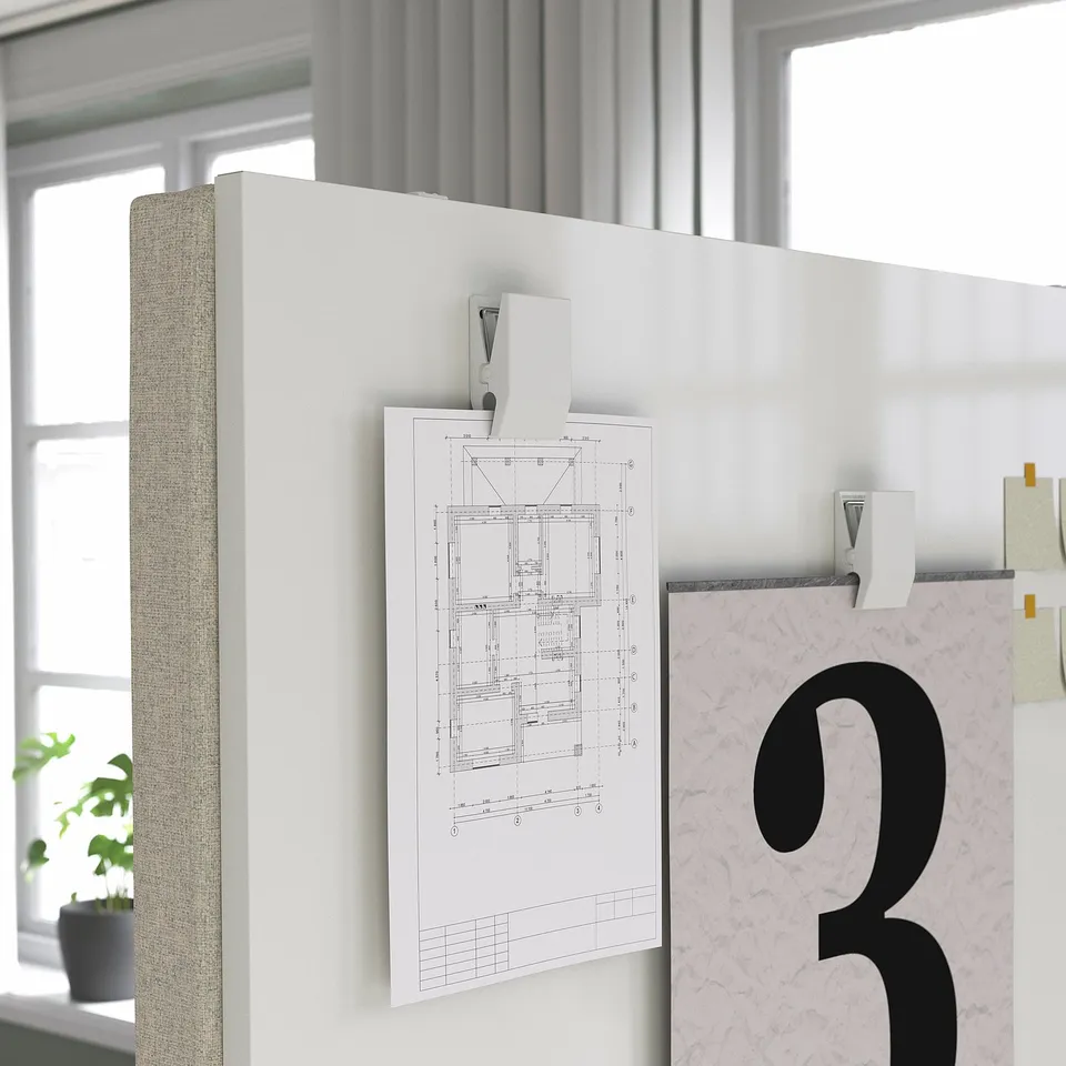 Wall-mounted acoustic screen with technical drawing pinned, featuring a fabric-covered, sound-absorbing panel, ideal for office use.