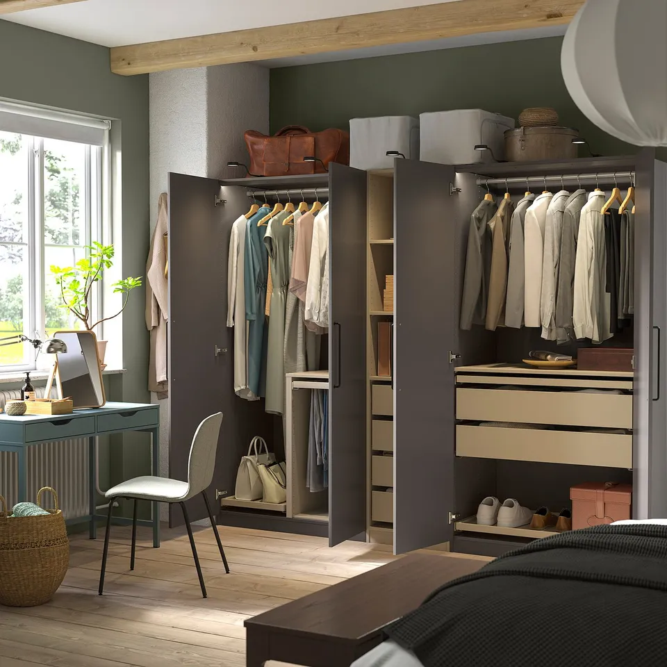 Modern bedroom with PAX wardrobes, neat clothes, and a desk by a large window.