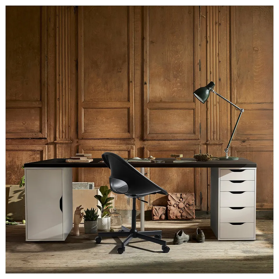 Well-organized home office a black LAGKAPTEN desk with wooden panels, a black swivel chair, and a stylish lamp.