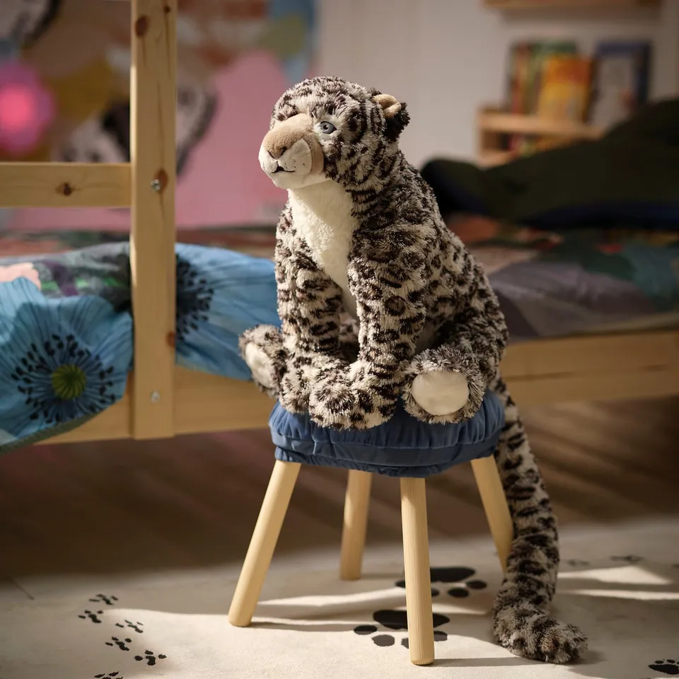 Childs room with blue ALPTALL stool. Life-sized, plush tiger toy sitting on it, looking relaxed. Room decorated with toys and colourful rugs.