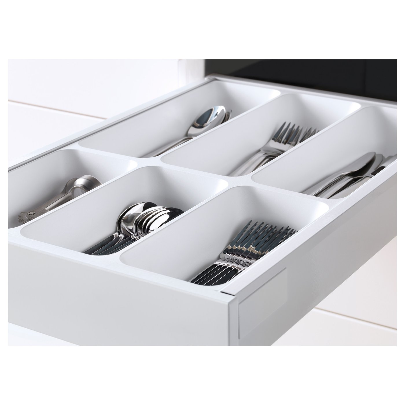 Open kitchen drawer with cutlery: spoons, forks, knives in compartments.