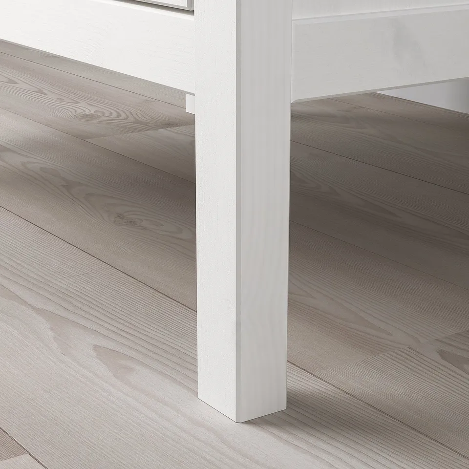 Elegant light wood floors meet clean, white bases. Refined, modern room corner, exuding quality and simplicity.