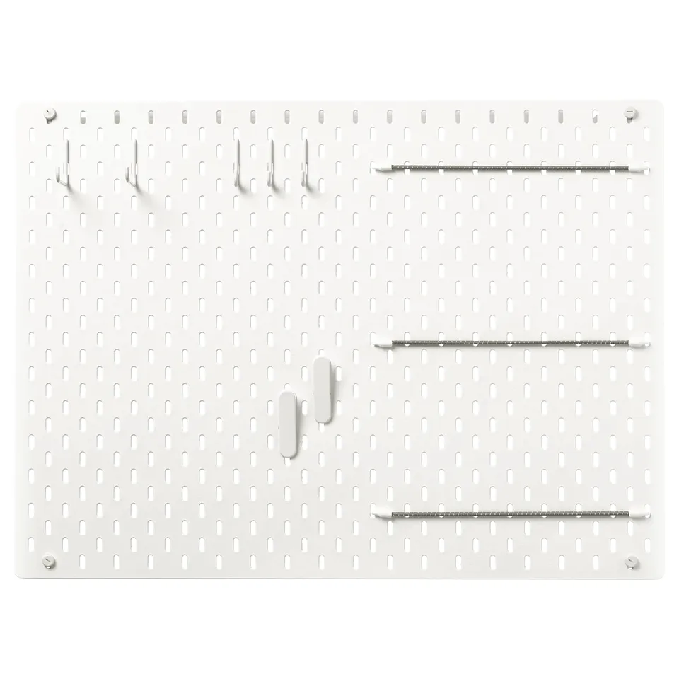 SKÅDIS pegboard in white with various hooks attached. Rectangular shape with multiple holes for hanging items.